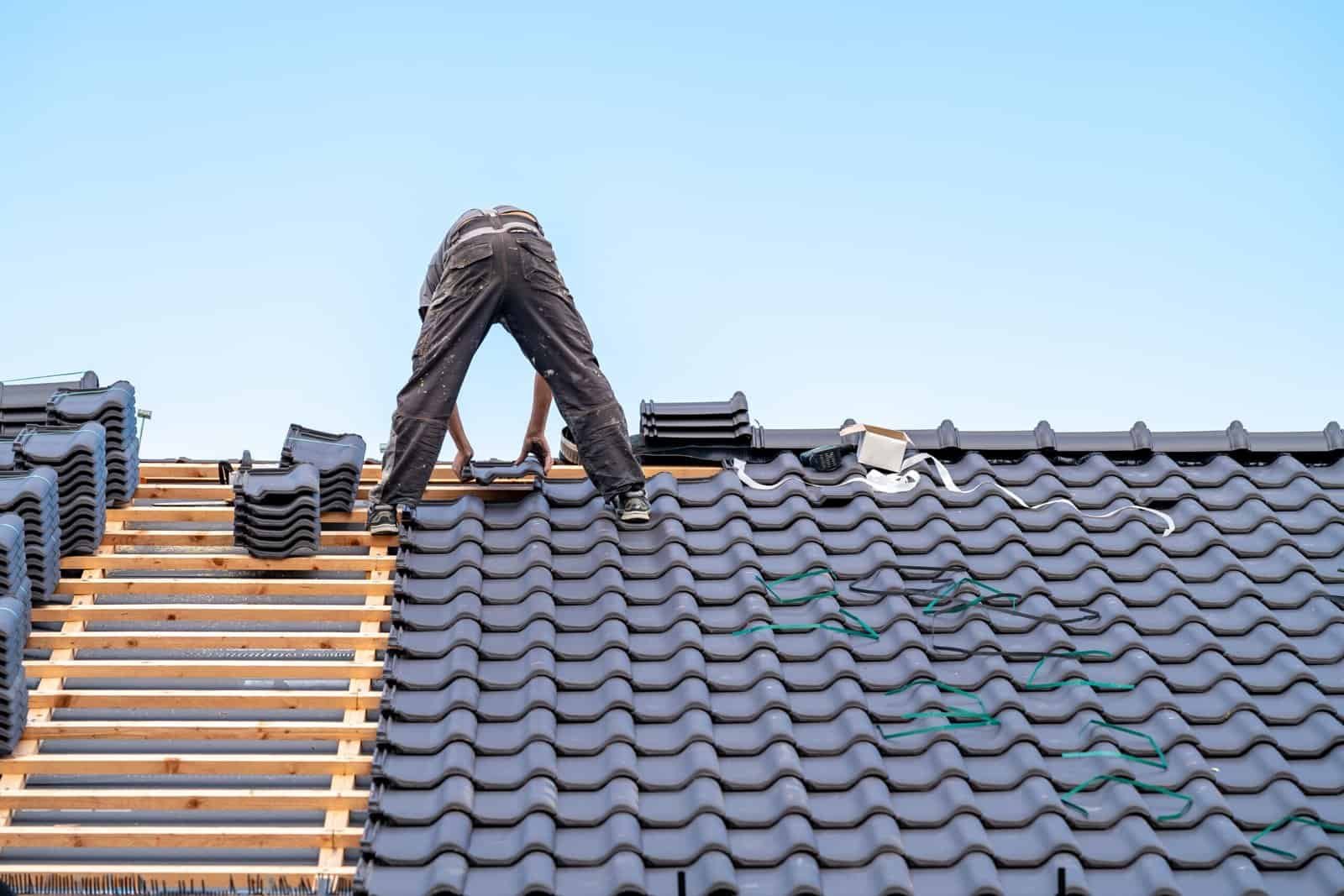 Roofing contractor installing tiles on a residential roof in Redlands, CA.