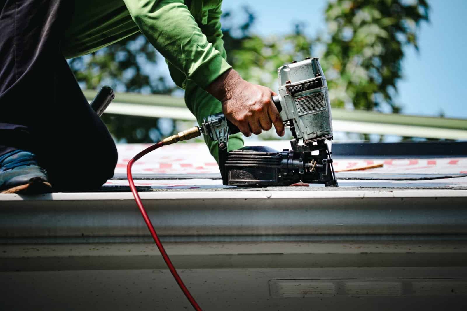 Roofing contractor installing shingles on a residential roof in Redlands, CA.